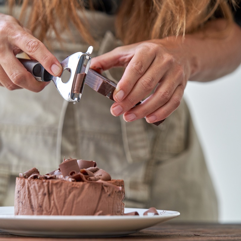 Using peeler to shave the chocolate