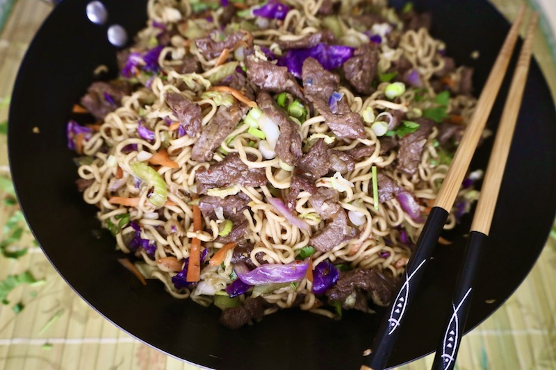 Beef Ramen Noodle Stir Fry in the wok with chop sticks horizontal image