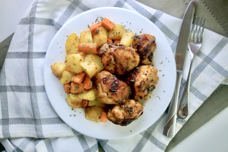 One Pan Baked Chicken Dinner on a plate next to a fork and knife